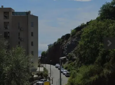 a street with cars parked on the side of a hill at 1-Bedroom Appartament mit Pool in Pržno
