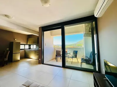 a living room with sliding glass doors and a view of the water at MonteСharm in Sutomore