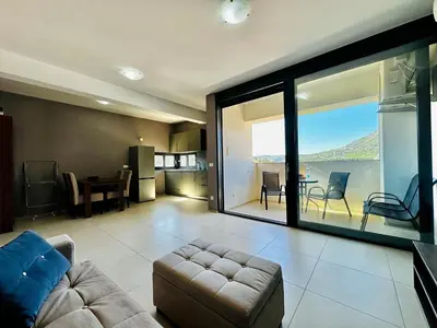 a living room with a couch and a large glass window at MonteСharm in Sutomore