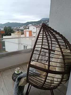 a rattan chair sitting on top of a balcony at SeaCharm in Dobra Voda