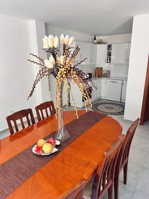 a dining room table with a vase of flowers on it at Villa Luna Blue in Brca