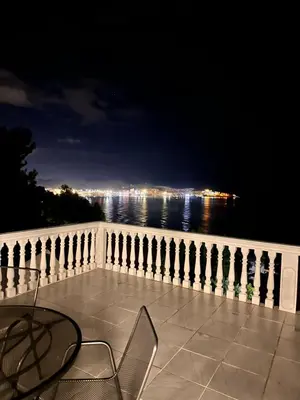 a table and chair on a balcony overlooking the water at Villa Luna Blue in Brca