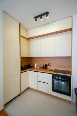 a kitchen with white cabinets and a stove at NYC Apartman with garage in Podgorica