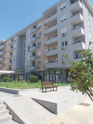 a park bench in front of a building at NYC Apartman with garage in Podgorica