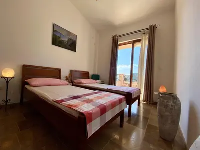 two beds in a room with a large window at Villa Nika in Brežani