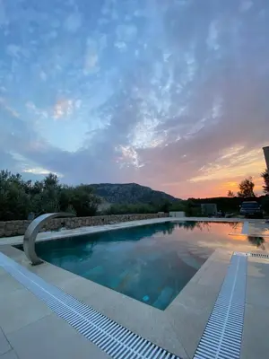 a swimming pool with a sunset in the background at Villa Nika in Brežani