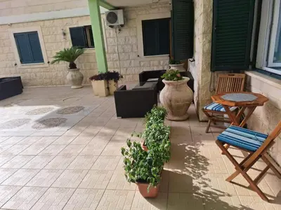 a patio with potted plants and a table and chairs at Montesan Luxury Apartments Sveti Stefan in Sveti Stefan