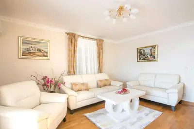 a living room with two white couches and a table at Montesan Luxury Apartments Sveti Stefan in Sveti Stefan