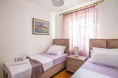 two beds in a room with a window at Montesan Luxury Apartments Sveti Stefan in Sveti Stefan