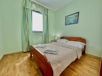 a bedroom with a bed and a window at Plava Vila Beach Apartments Sveti Stefan in Sveti Stefan