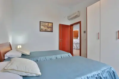 a bedroom with two beds and a door to a room at Plava Vila Beach Apartments Sveti Stefan in Sveti Stefan