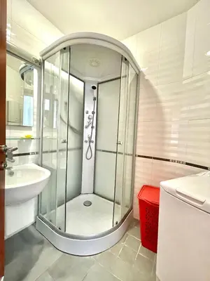 a glass shower in a bathroom with a sink at Plava Vila Beach Apartments Sveti Stefan in Sveti Stefan