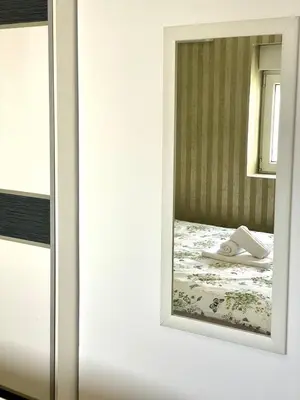 a mirror on a wall next to a bed at City center 34 in Podgorica