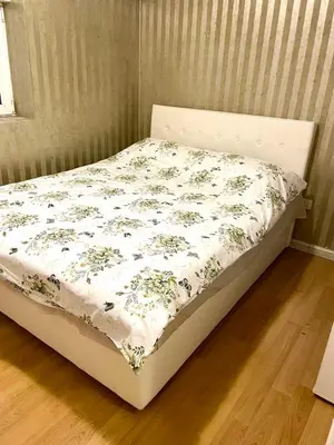 a bed in a room with a floral bedspread at City center 34 in Podgorica