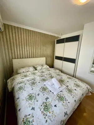 a small bedroom with a bed with a floral bedspread at City center 34 in Podgorica