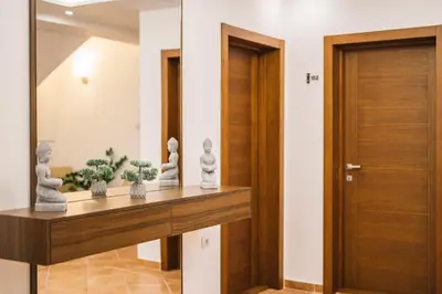a hallway with a wooden door and some plants on a shelf at Villa Oleander in Ulcinj