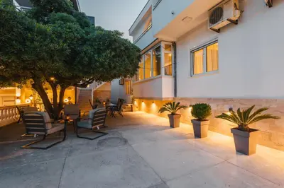 a patio with chairs and trees and a building at Villa Oleander in Ulcinj