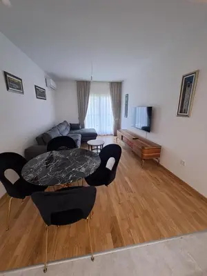 a living room with a table and chairs and a couch at Apartman Vlado Podgorica in Podgorica