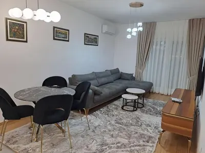 a living room with a couch and a table and chairs at Apartman Vlado Podgorica in Podgorica
