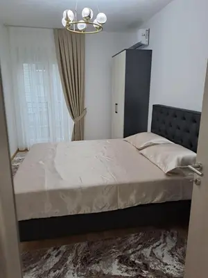 a bedroom with a bed and a chandelier at Apartman Vlado Podgorica in Podgorica
