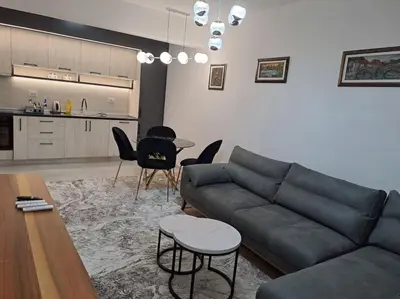 a living room with a couch and a table and chairs at Apartman Vlado Podgorica in Podgorica