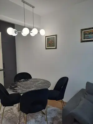 a dining room with a table and chairs and a couch at Apartman Vlado Podgorica in Podgorica