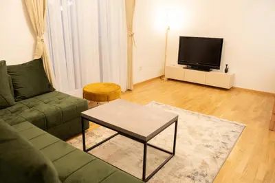 a living room with a couch and a tv at Apartament ZHana in Podgorica