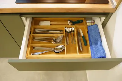 a drawer filled with silver utensils in a cabinet at Apartament ZHana in Podgorica