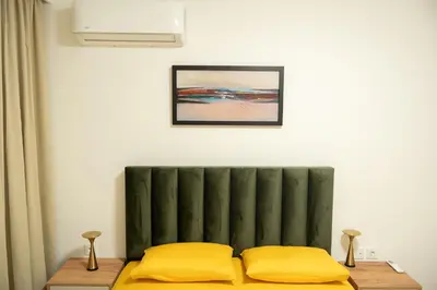a bedroom with a bed with yellow pillows at Apartament ZHana in Podgorica