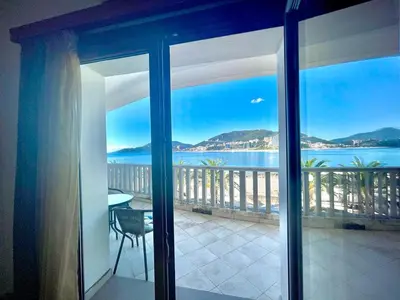 a room with a view of the water from a balcony at Sea view Apartments Rafailovici in Budva