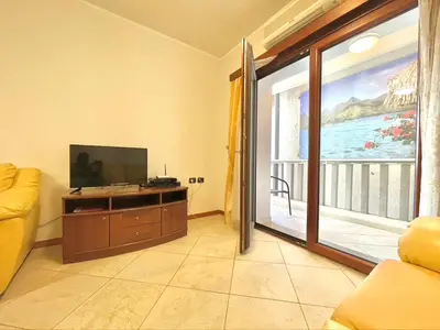 a living room with a television and a large window at Sea view Apartments Rafailovici in Budva