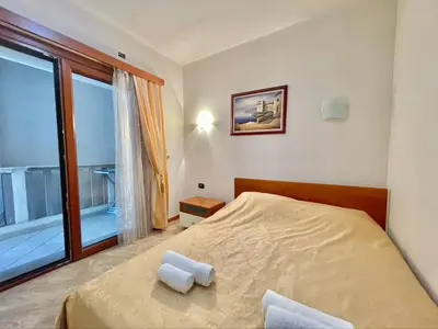 a bedroom with a bed and a large window at Sea view Apartments Rafailovici in Budva