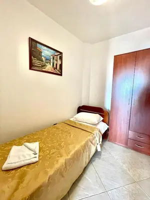 a bedroom with two beds and a wooden cabinet at Sea view Apartments Rafailovici in Budva