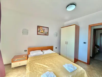 a bedroom with a bed and a cabinet in it at Sea view Apartments Rafailovici in Budva