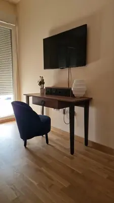 a living room with a desk with a tv and a chair at Apartment Katarina in Podgorica