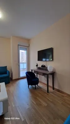 a living room with a desk and a blue chair at Apartment Katarina in Podgorica