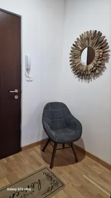 a blue chair in a room with a mirror at Apartment Katarina in Podgorica