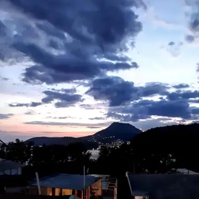 a cloudy sky with a mountain in the background at Apartments Vitic in Sutomore