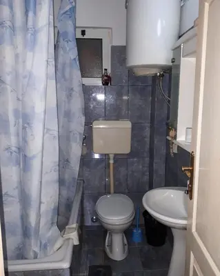 a small bathroom with a toilet and a sink at Apartments Vitic in Sutomore