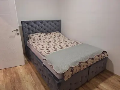 a bed in a corner of a room at DMD Apartman in Podgorica