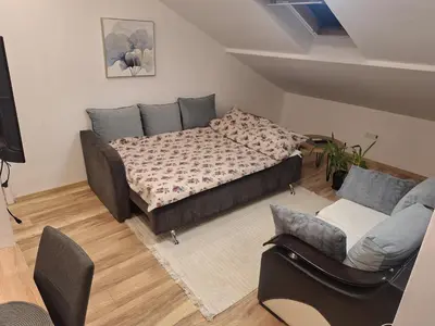 a living room with a bed and a couch at DMD Apartman in Podgorica