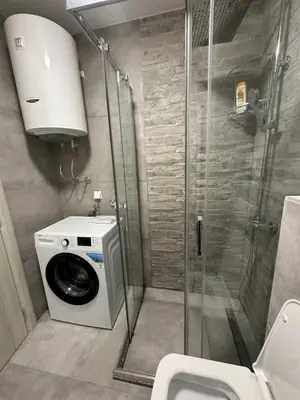 a bathroom with a washing machine and a shower at Apartman Vesna Budva 2 in Lugovi