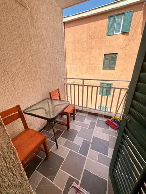 a patio with a table and chairs on a balcony at Apartman Vesna Budva 2 in Lugovi