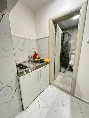 a white kitchen with a counter and a sink at Apartman Vesna Budva 2 in Lugovi