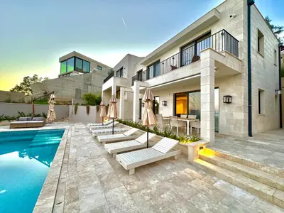 a house with a swimming pool with chairs and umbrellas at Exclusive villa Kaza - Przno in Budva