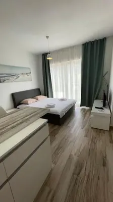 a bedroom with a bed and a wooden floor at Sunny Studio in Bečići in Budva