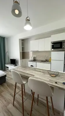 a kitchen with a wooden table and two white chairs at Sunny Studio in Bečići in Budva
