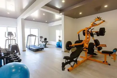 a gym with treadmills and exercise equipment in a room at Sunny Studio in Bečići in Budva