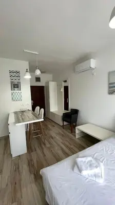 a bedroom with a bed and a table and a dining room at Sunny Studio in Bečići in Budva