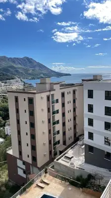 a view of a building with mountains in the background at Sunny Studio in Bečići in Budva